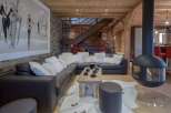Experience luxury living in this stunning property, featuring a cozy living room with a modern fireplace and a comfortable sectional sofa.