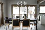 This dining room features a modern black table and chairs, complemented by a stylish chandelier.