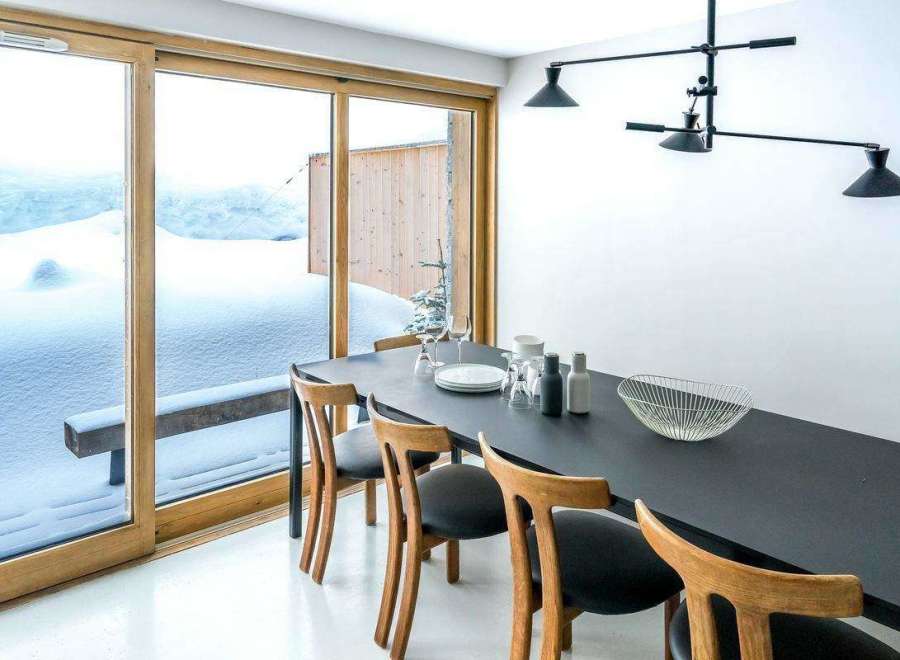 This stunning property boasts a modern dining area with a sleek black table and stylish wooden chairs.