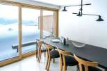 This stunning property boasts a modern dining area with a sleek black table and stylish wooden chairs.