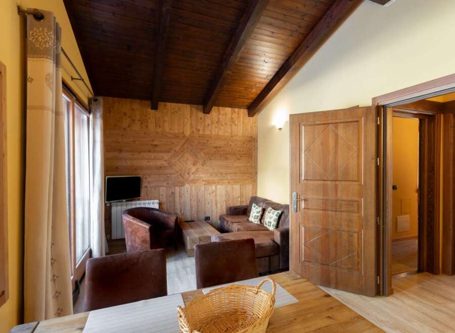 Experience rustic charm in this cozy living space, featuring a warm wooden ceiling and walls.