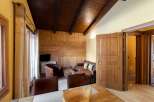 Experience rustic charm in this cozy living space, featuring a warm wooden ceiling and walls.