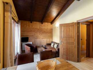 Experience rustic charm in this cozy living space, featuring a warm wooden ceiling and walls.