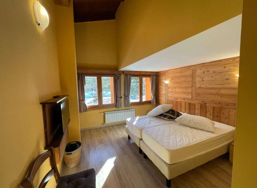 Cozy bedroom with wooden accents and a comfortable bed.