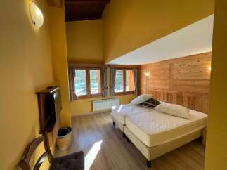 Cozy bedroom with wooden accents and a comfortable bed.