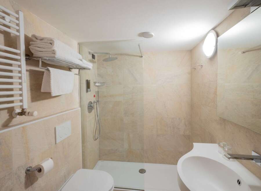 This modern bathroom features a sleek design with a walk-in shower and a stylish sink.