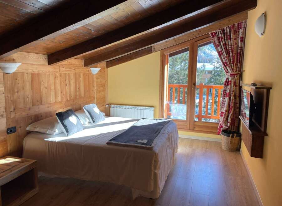Cozy up in this charming bedroom with its rustic wooden accents and inviting ambiance.