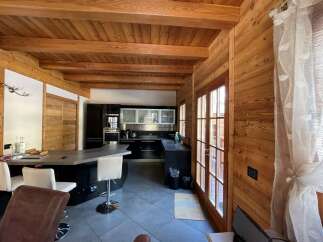 Step into a cozy kitchen with a rustic wooden ceiling and walls, creating a warm and inviting atmosphere.