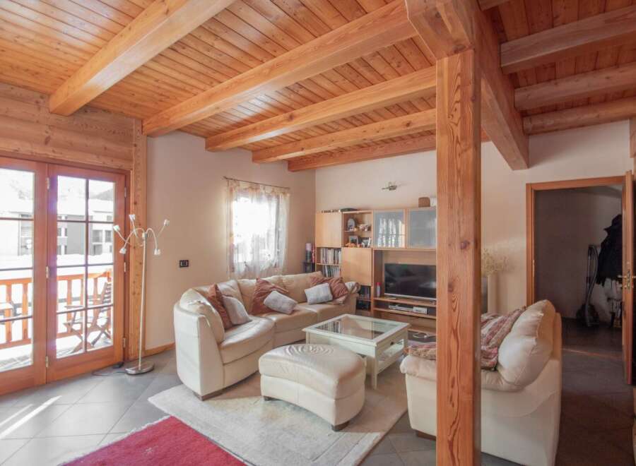 This stunning property boasts a warm and inviting interior with exposed wooden beams and a cozy living space.