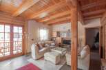 This stunning property boasts a warm and inviting interior with exposed wooden beams and a cozy living space.