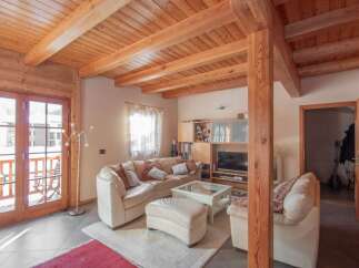 This stunning property boasts a warm and inviting interior with exposed wooden beams and a cozy living space.