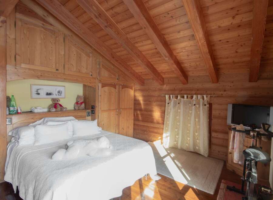 Experience the warmth of this cozy bedroom, featuring stunning wooden accents throughout.