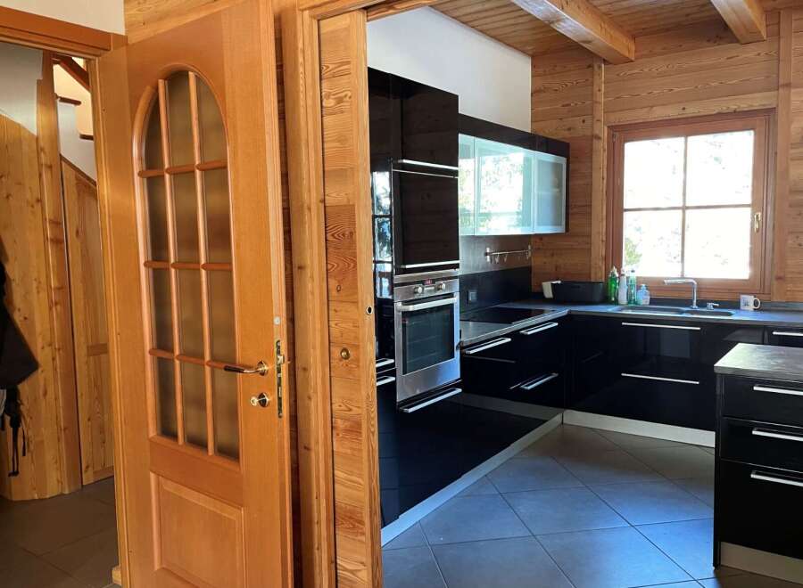 Step into this stunning kitchen with sleek black cabinetry and modern appliances.