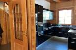 Step into this stunning kitchen with sleek black cabinetry and modern appliances.