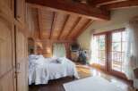This cozy bedroom features a stunning wooden ceiling and walls, creating a warm and inviting atmosphere.