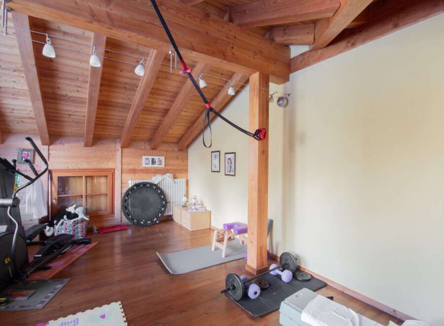 This stunning home gym boasts a rustic charm with its wooden beams and flooring.