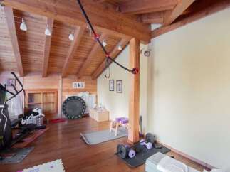 This stunning home gym boasts a rustic charm with its wooden beams and flooring.