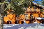 Discover a charming wooden chalet nestled in a snowy landscape.