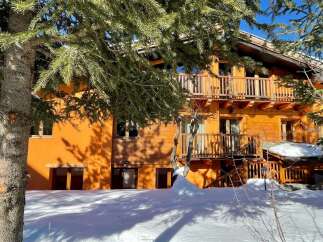 Discover a charming wooden chalet nestled in a snowy landscape.