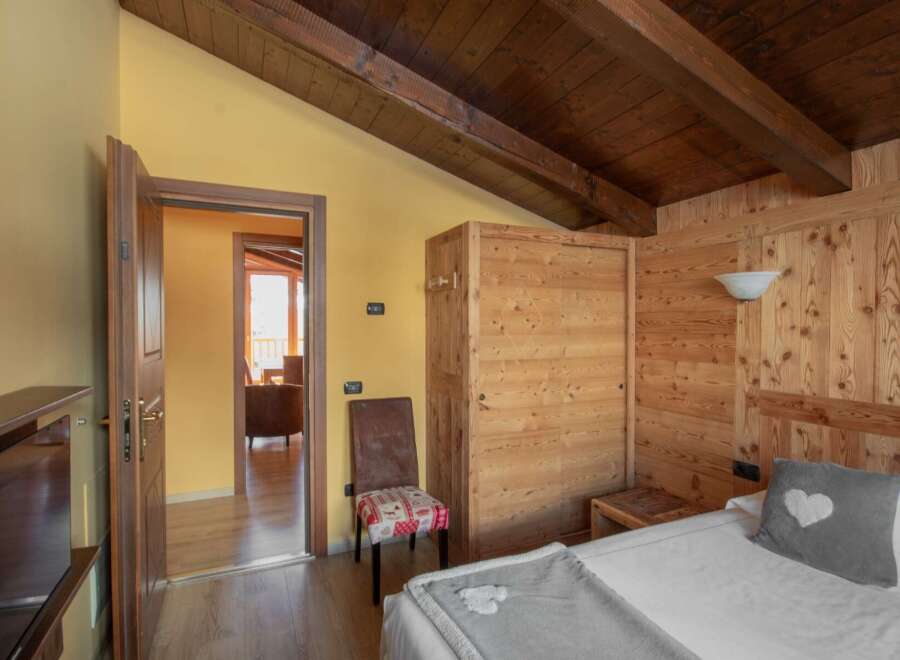 Discover a cozy bedroom with rustic charm, featuring wooden paneling and a warm, inviting atmosphere.