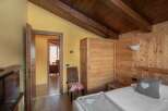 Discover a cozy bedroom with rustic charm, featuring wooden paneling and a warm, inviting atmosphere.