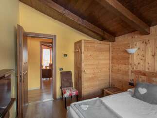 Discover a cozy bedroom with rustic charm, featuring wooden paneling and a warm, inviting atmosphere.