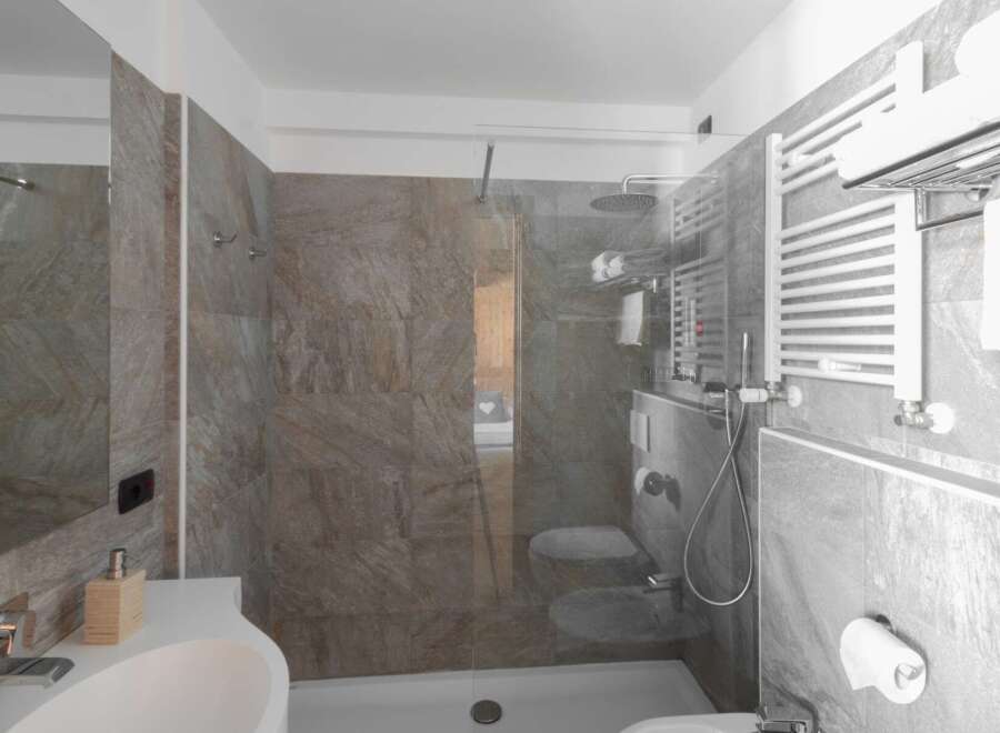 This modern bathroom features a sleek glass shower enclosure and stylish gray tile.