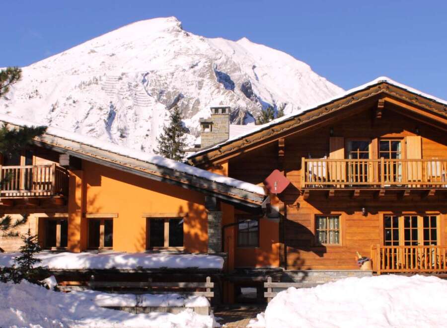 Experience the charm of a cozy wooden chalet nestled in a snowy mountain landscape.