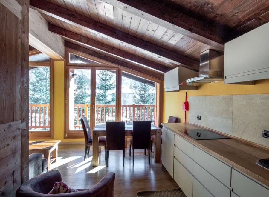 Experience the charm of this cozy chalet with its stunning wooden ceiling and inviting dining area.