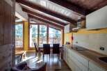 Experience the charm of this cozy chalet with its stunning wooden ceiling and inviting dining area.