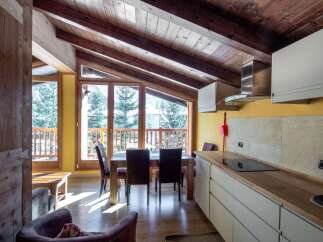 Experience the charm of this cozy chalet with its stunning wooden ceiling and inviting dining area.
