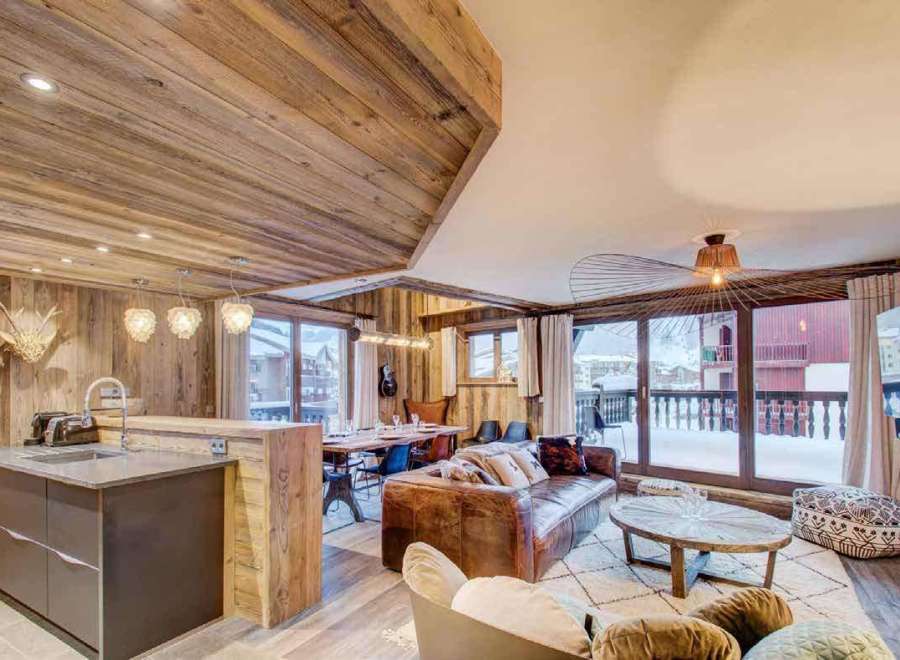 Experience luxury living in this stunning chalet, featuring a warm and inviting interior with wooden accents throughout.