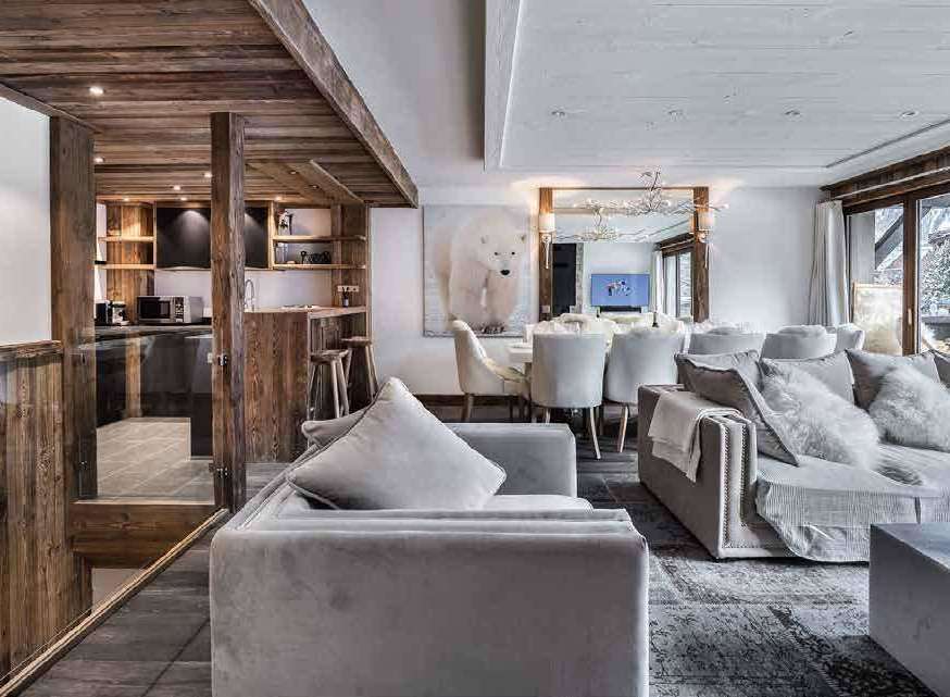 Experience luxury living in this stunning property, featuring a cozy living room with plush seating and a modern kitchen.