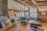 Experience luxury living in this stunning chalet, boasting a warm and inviting interior with exposed wooden beams and a cozy fireplace.