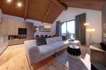 Experience luxury living in this stunning property, featuring a modern kitchen and a cozy living area with a comfortable sofa.