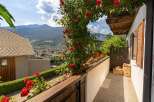 Enjoy breathtaking mountain views from this charming balcony, adorned with vibrant red roses.