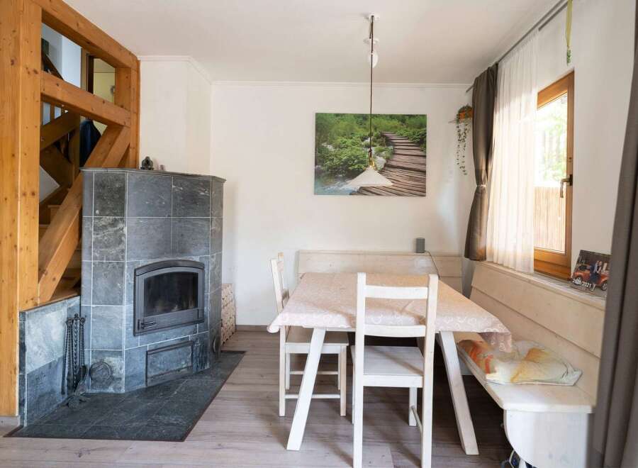 This charming property features a cozy dining area with a rustic wooden table and chairs, perfect for intimate gatherings.