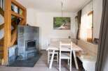 This charming property features a cozy dining area with a rustic wooden table and chairs, perfect for intimate gatherings.