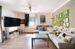This inviting living room boasts a modern aesthetic with a large flat-screen TV, perfect for entertainment.