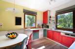 This charming kitchen boasts a vibrant and inviting atmosphere with its colorful cabinetry and ample natural light.