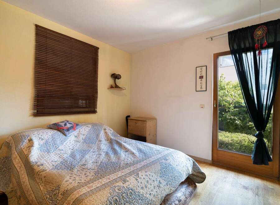 Cozy bedroom with natural light and wooden accents.