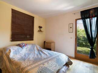 Cozy bedroom with natural light and wooden accents.