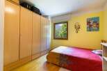 This cozy bedroom features a large wooden wardrobe, providing ample storage space.