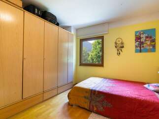 This cozy bedroom features a large wooden wardrobe, providing ample storage space.