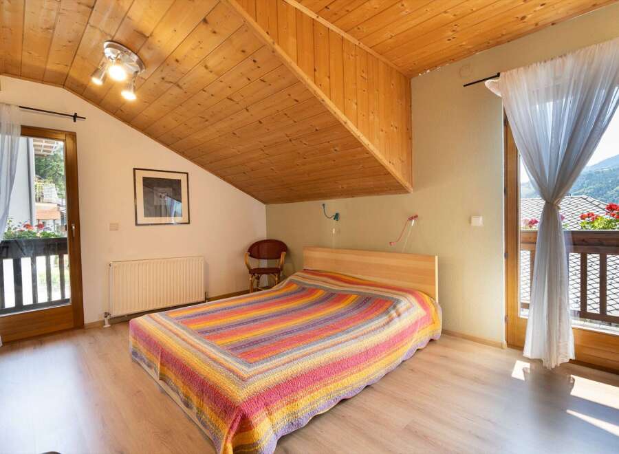 Discover a cozy bedroom with a unique wooden ceiling design.