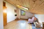 Discover a cozy retreat with a unique sloped ceiling and natural wood accents.