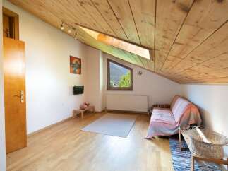Discover a cozy retreat with a unique sloped ceiling and natural wood accents.