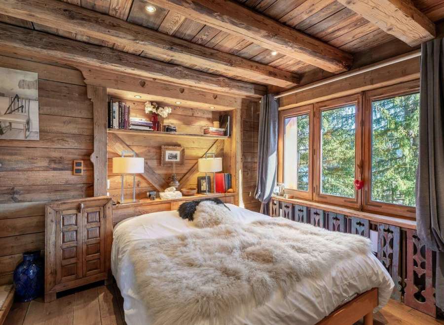 Experience rustic charm in this cozy bedroom, featuring exquisite wooden paneling and a warm, inviting atmosphere.