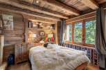 Experience rustic charm in this cozy bedroom, featuring exquisite wooden paneling and a warm, inviting atmosphere.