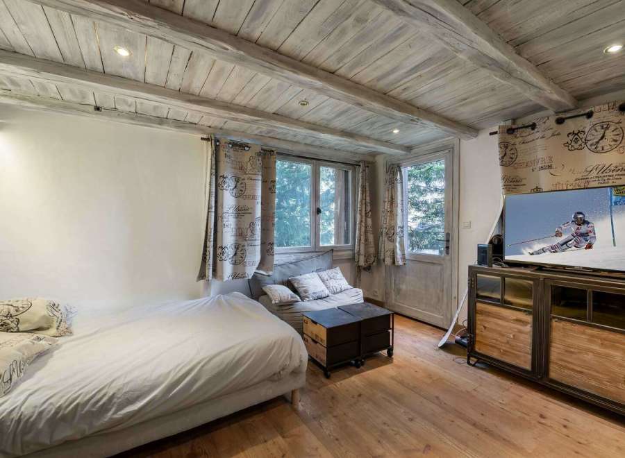 This cozy room features a rustic wooden ceiling and floors, creating a warm and inviting atmosphere.